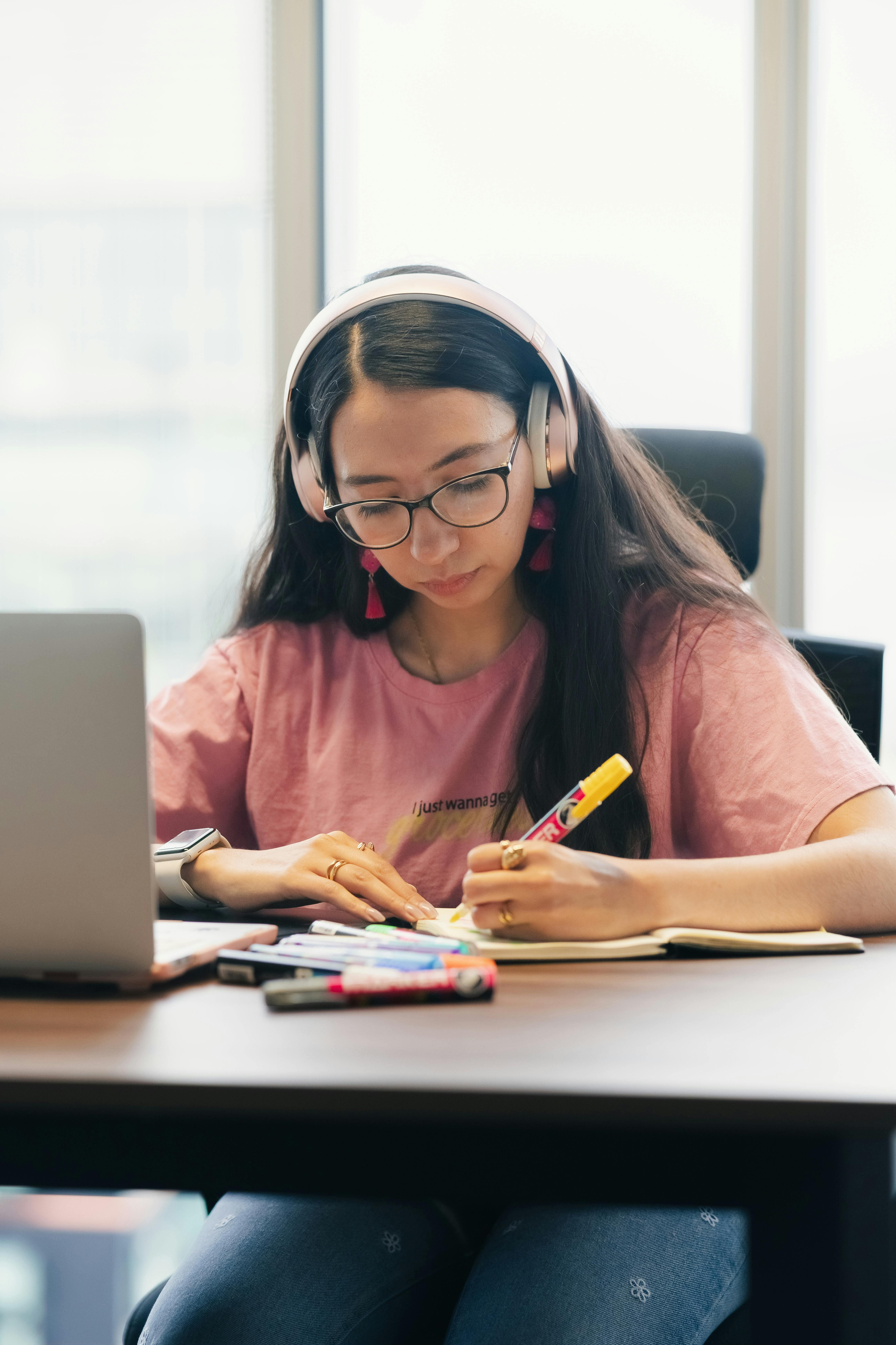 Estudiante tomando notas frente a una laptop